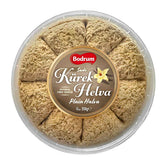 A round 350g Bodrum Plain Kurek Halva, divided into eight segments, comes in a clear-lidded plastic container with a central label, featuring classic sesame halva flavor.